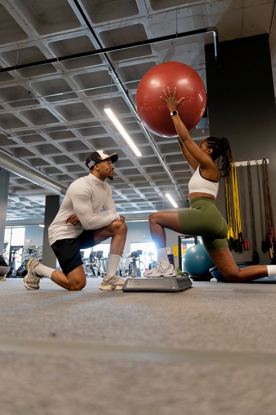 Bobby J coaching a client through a kneeling stability ball press